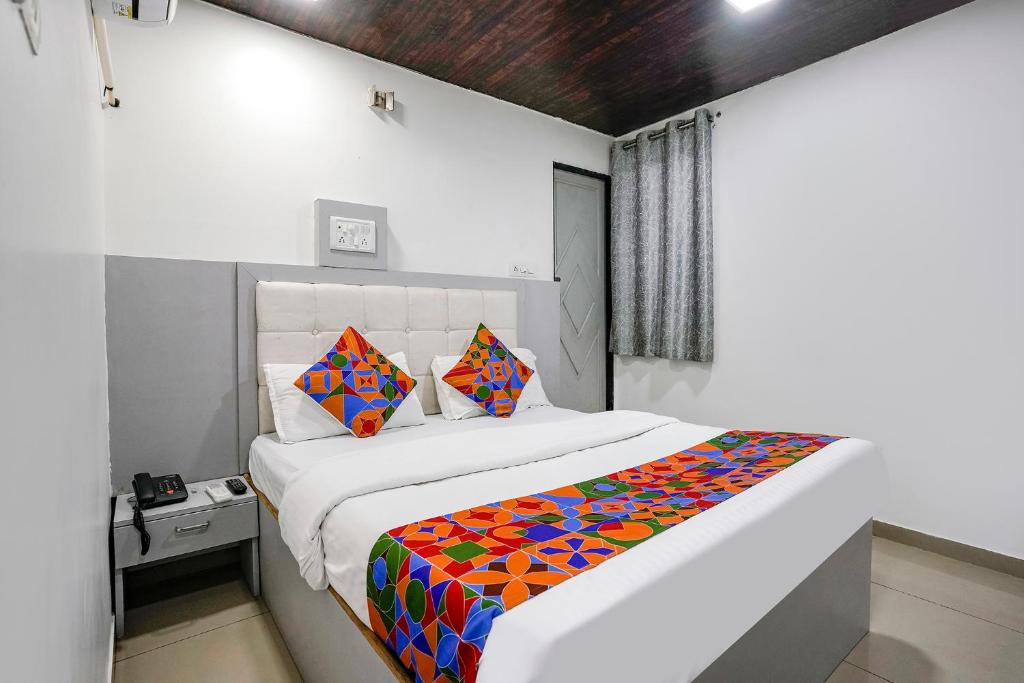 FabHotel Park Residency في مومباي: غرفة نوم مع سرير كبير مع بطانية ملونة