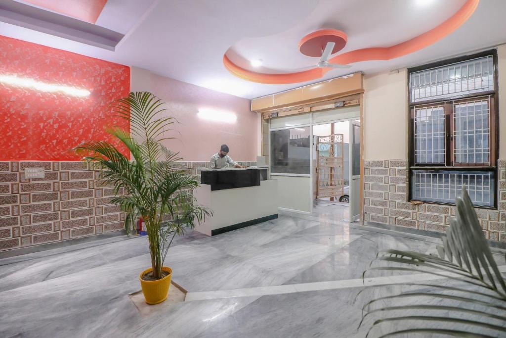 a lobby with a counter and a person in the background at Primrose Hotel's Near Noida Sector Metro Station in Noida