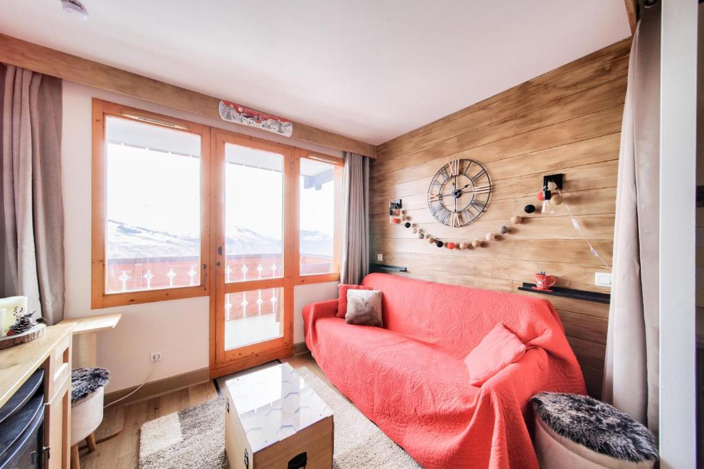 - un salon avec un canapé rouge et une fenêtre dans l'établissement Résidence La Marelle et Le Rami - maeva Home - Appartement 2 pièces 4 personnes - Sélection MAE-0944, à La Plagne Tarentaise