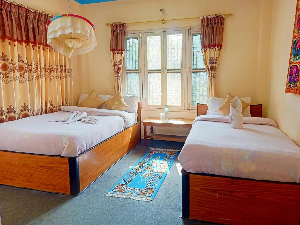 een slaapkamer met 2 bedden en een raam bij Hotel Rhinoceros-Homestay in Sauraha