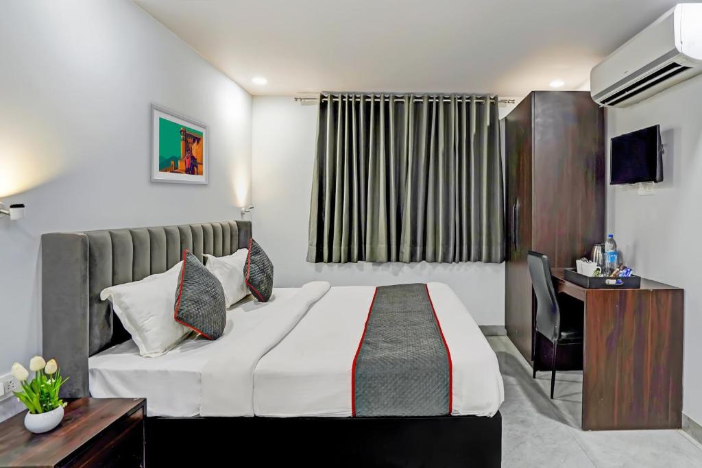 um quarto de hotel com uma cama e uma secretária em Super Townhouse 1263 Shalimar Residency Near Shalimar Bagh Metro Station em Nova Deli