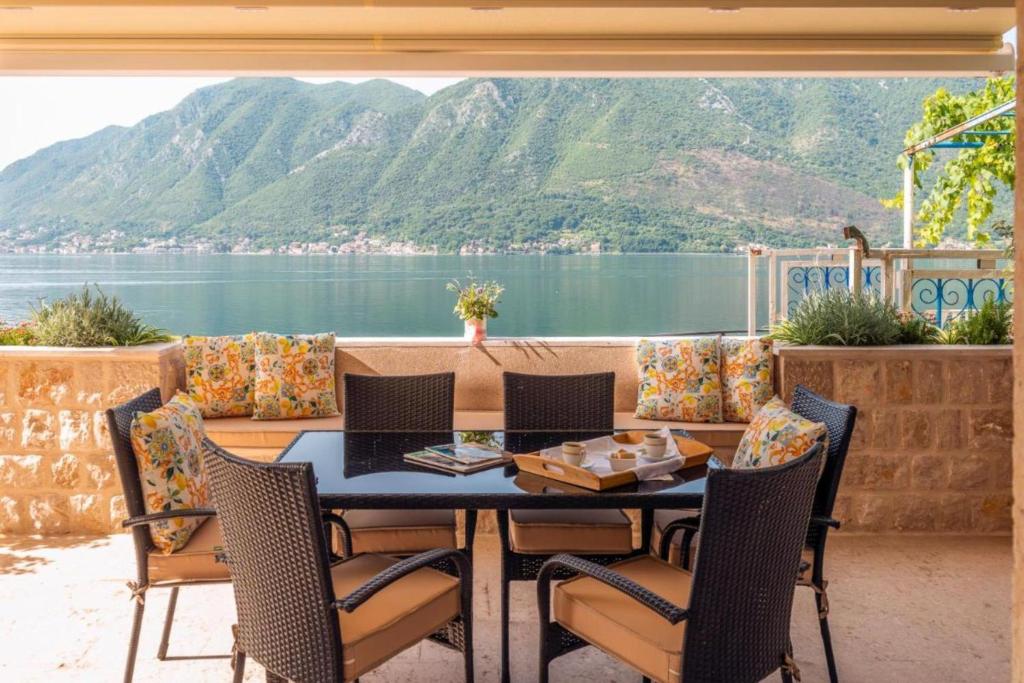 un tavolo e sedie con vista sull'acqua di Luxury Pool Villa Feliz a Kotor (Cattaro)