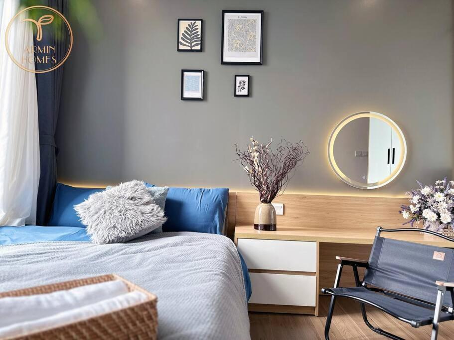 1 dormitorio con cama, espejo y silla en Armin Homes 2 Bedroom apartment at Ecopark, en Kim Quan