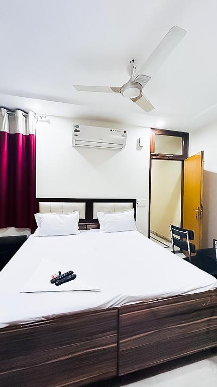a bedroom with a large bed with a remote control on it at Hotel VIOLET GOVINDPURI in New Delhi