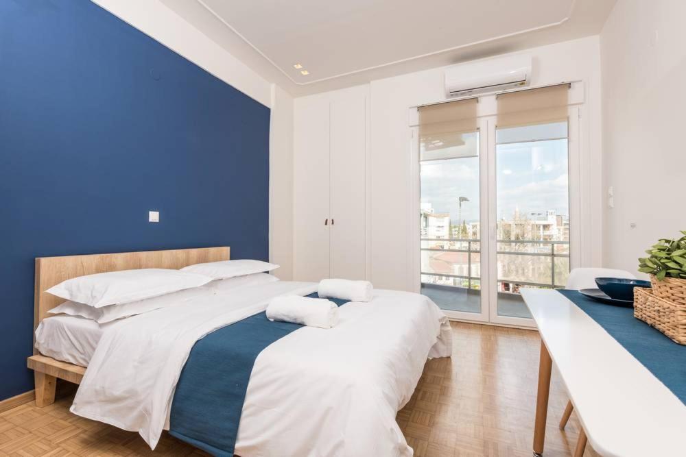 a bedroom with two beds and a blue wall at Pantheon spuare view 3 in Komotini