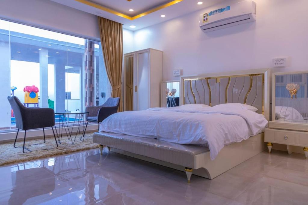 a bedroom with a large bed and a table and chairs at بهجة الجبل الأخضر in Ḩayl Yaman