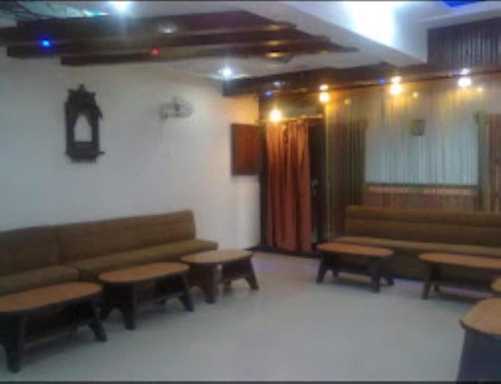 a waiting room with couches and tables in a building at Hotel Yadu Residency Meerut in Meerut