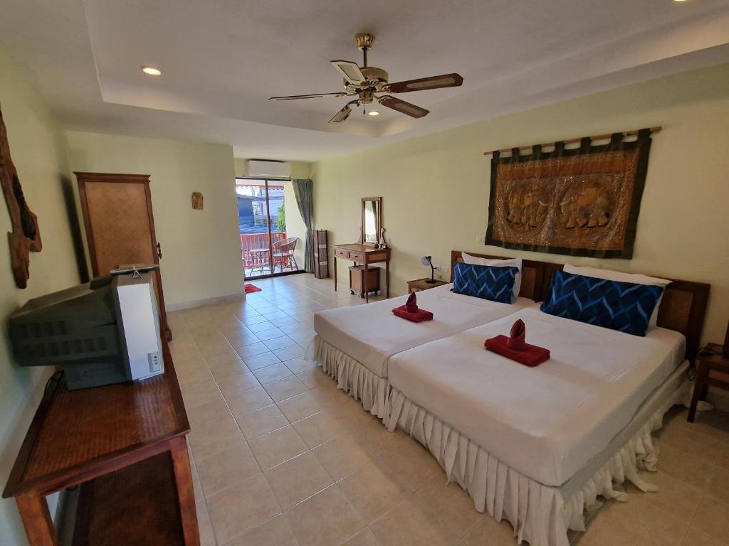 a bedroom with a bed with two red shoes on it at Villa Oranje Chiang Mai in Chiang Mai