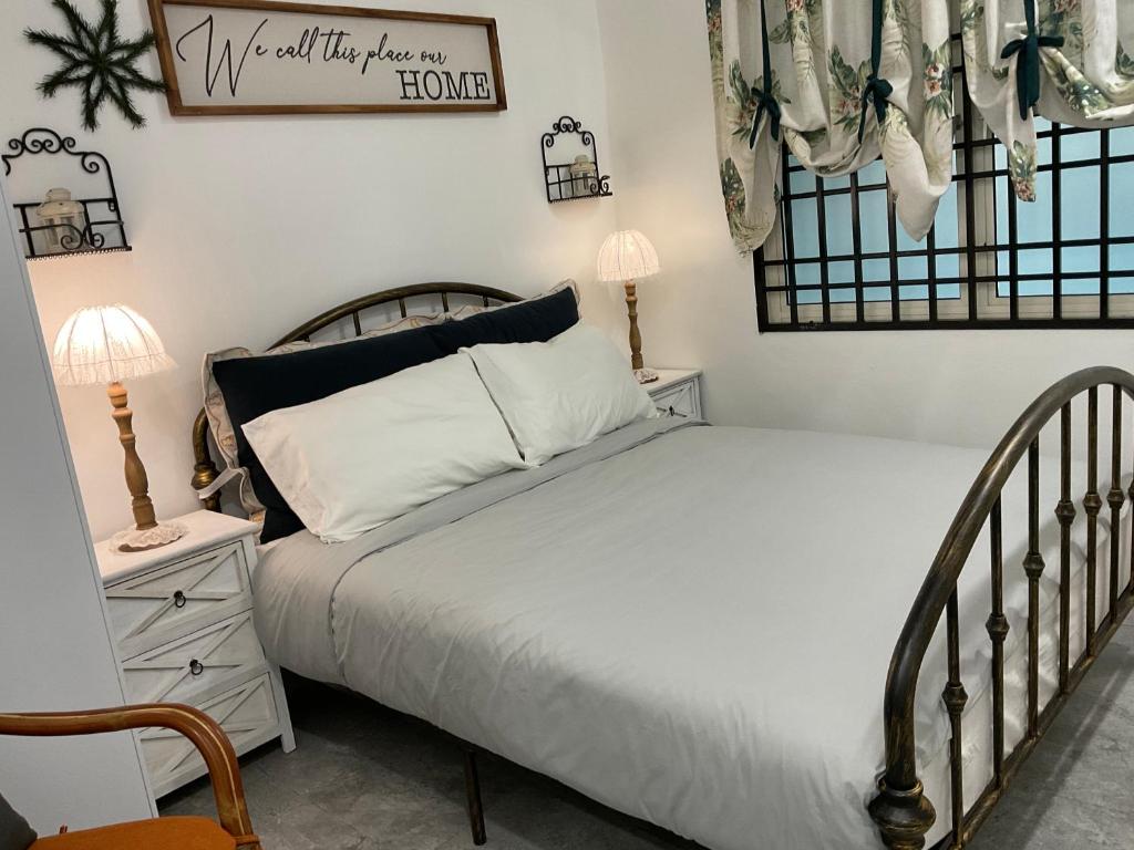 a bedroom with a bed and a sign on the wall at Jessie Home in Bukit Mertajam