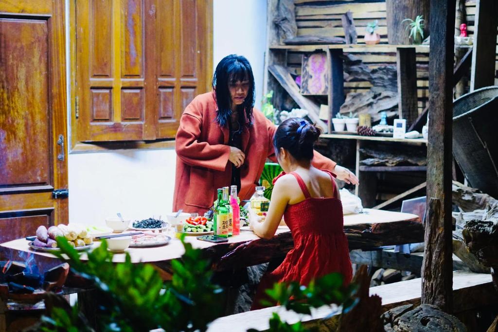 two women standing in a kitchen preparing food at Người Măng Đen Homestay in Kon Von Kla