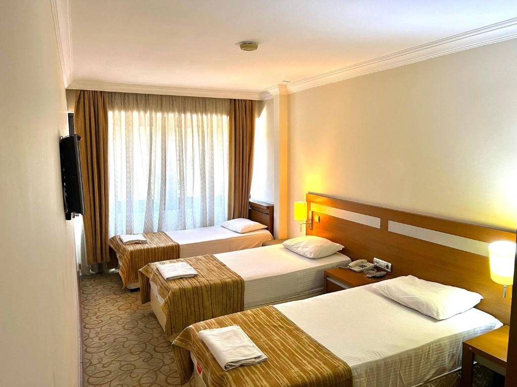 a hotel room with two beds and a television at STAYCITY OTEL in Altındağ