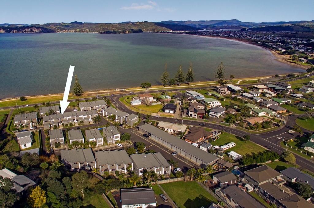an aerial view of a suburb next to the water at Aqua Soleil Beachfront Apartment in Whitianga