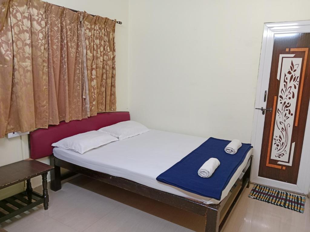 niewielka sypialnia z łóżkiem i oknem w obiekcie HOTEL SUNANDA LODGE w mieście Belagavi
