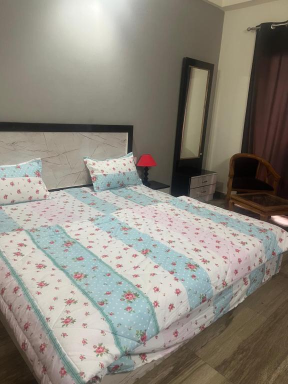una camera da letto con un letto con un piumone di Paramount studio near pari chowk a Greater Noida