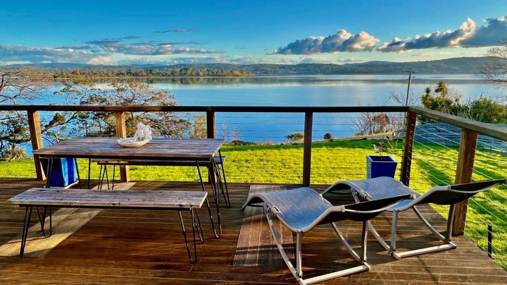 - une table et des chaises sur une terrasse avec vue sur le lac dans l'établissement Hillwood Havana, à Hillwood