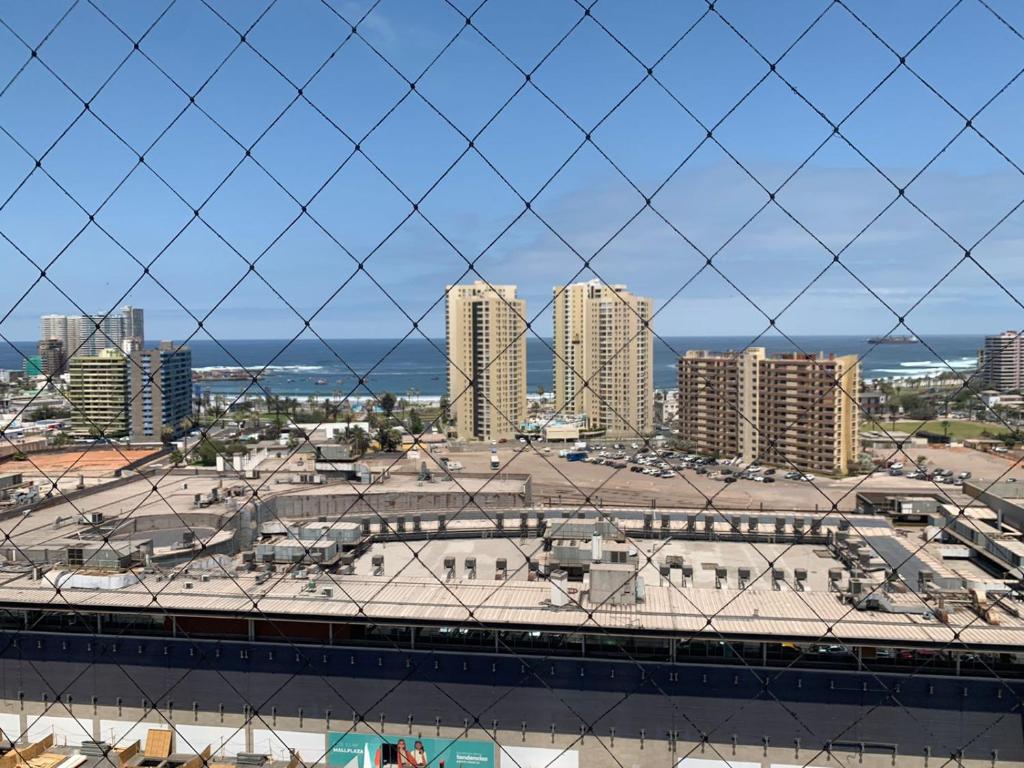 a view of a city from behind a chain link fence at Depto. Edificio Miramar 2D 2B cerca de Playa Cavancha in Iquique
