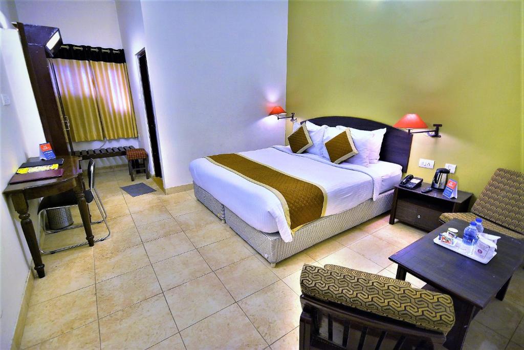 焦特布爾的住宿－Rajputana Palace，酒店客房设有一张大床和一张书桌。