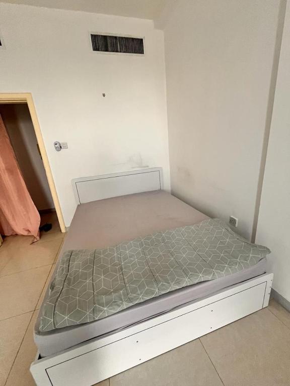 a small bed in a room with at Near Alain Main Bus Stop, in Al 'Ayn