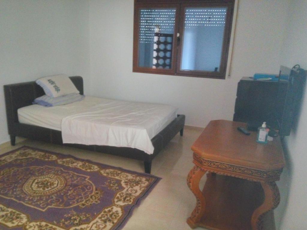 um pequeno quarto com uma cama e uma mesa em Villa Alhucemas 