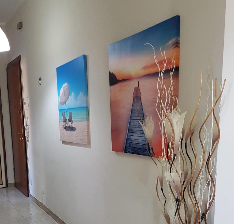 three pictures hanging on a wall in a room at Il Nido di Pikki in Falconara Marittima