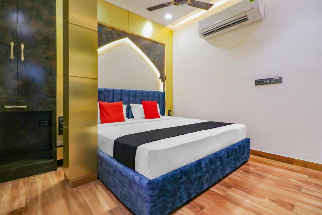 1 dormitorio con 1 cama grande con almohadas rojas en Capital O Hotel Western Galaxy, en Amritsar