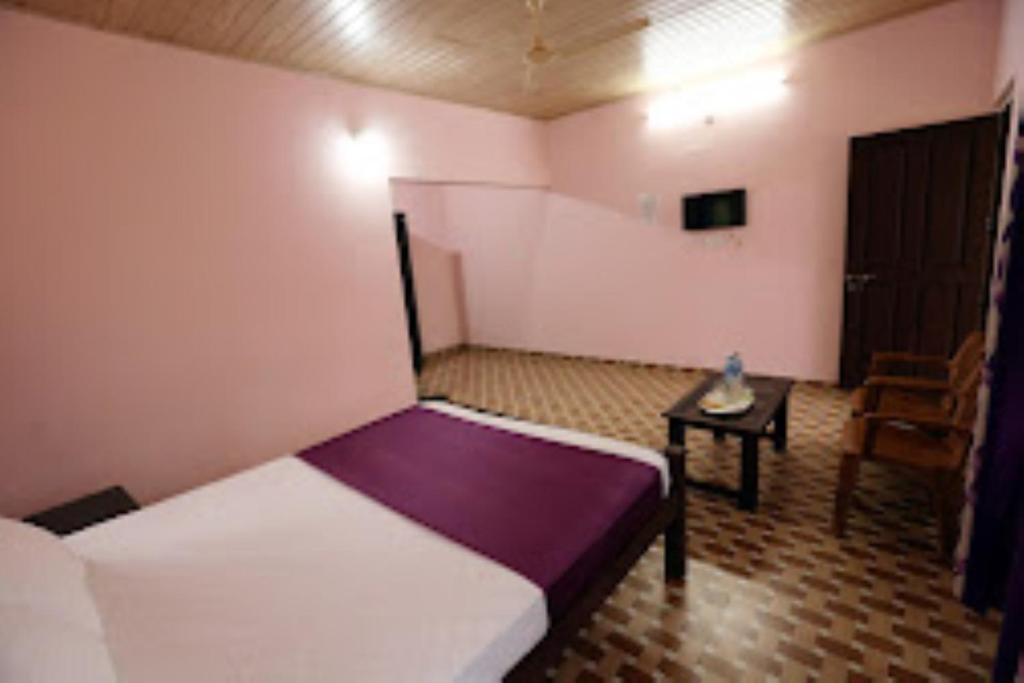 a bedroom with a bed and a table in it at Himadri Retreat Homestay Wayanad in Kaniyāmbetta