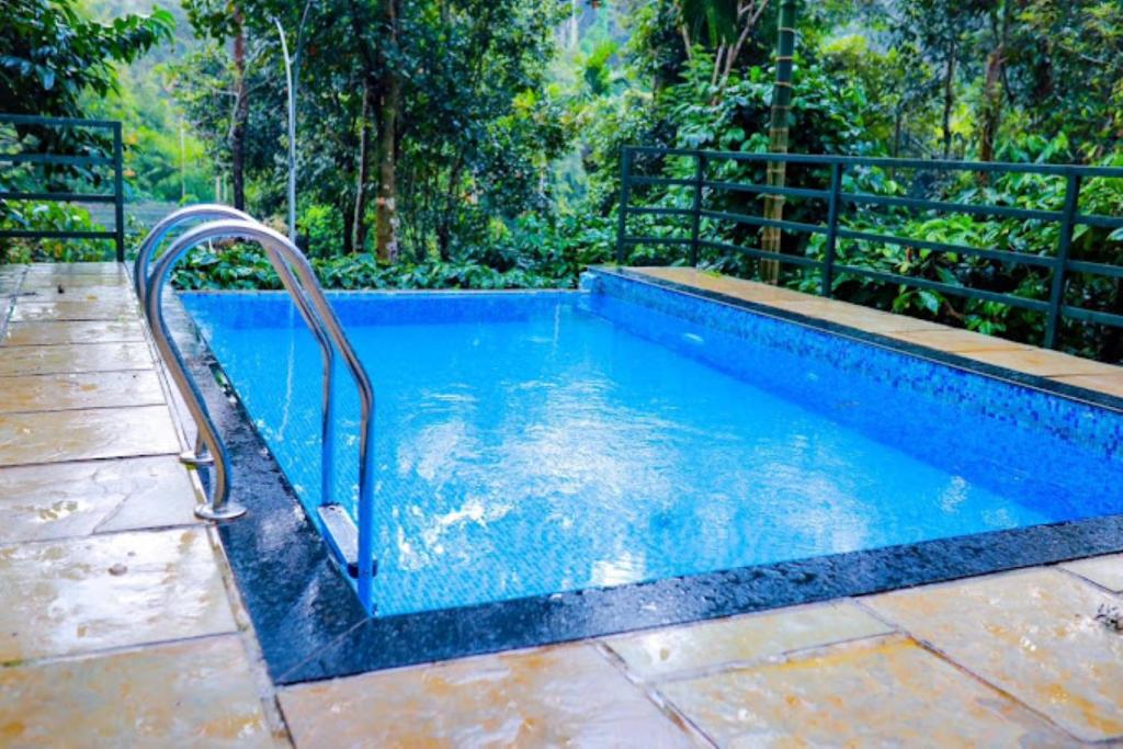 una piscina con una valla de metal alrededor en Park Place Holiday Home Kerala, en Vythiri