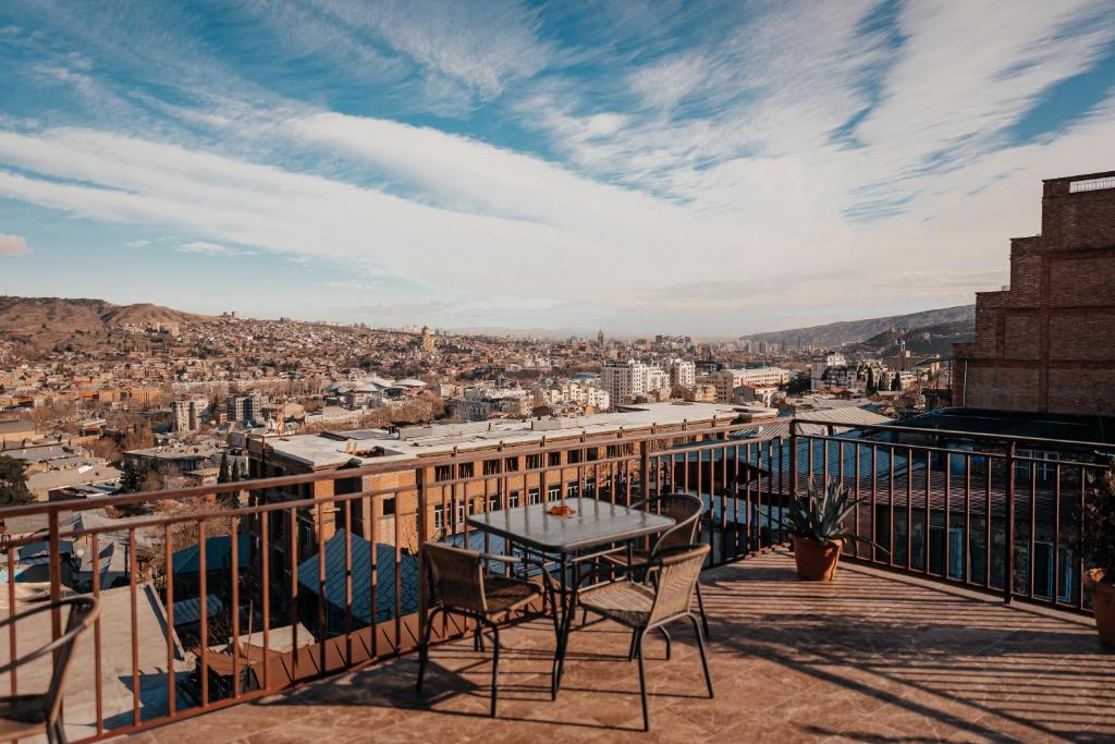 um pátio com uma mesa e cadeiras numa varanda em Apartment on Borbalo 16 em Tbilisi