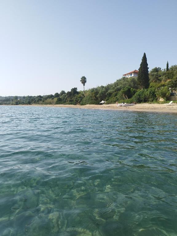 a body of water with a beach in the background at Takis Haikos House two minutes walk to the beach Peroulia in Vounaria