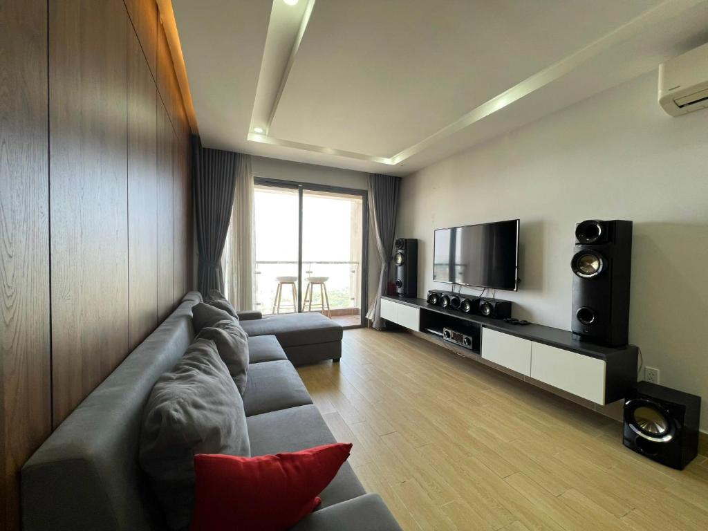 un soggiorno con divano e TV di The Gold View Apartment Q4, 2PN2WC ad Ho Chi Minh