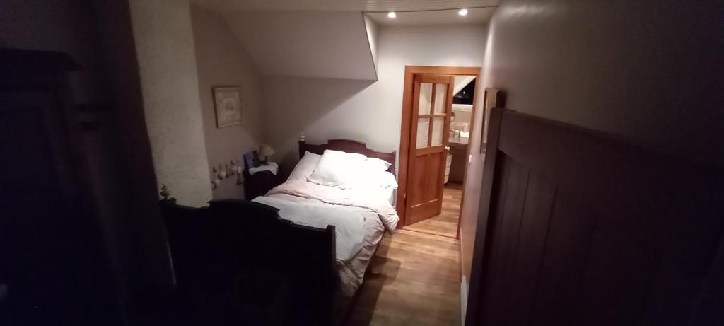 ein Schlafzimmer mit einem Bett mit weißer Bettwäsche und einem Eingang in der Unterkunft MENFOUTI in Saint-Béat