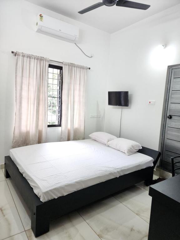a bedroom with a bed and a ceiling fan at Olive Home stay Gold 1bhk in Alwaye