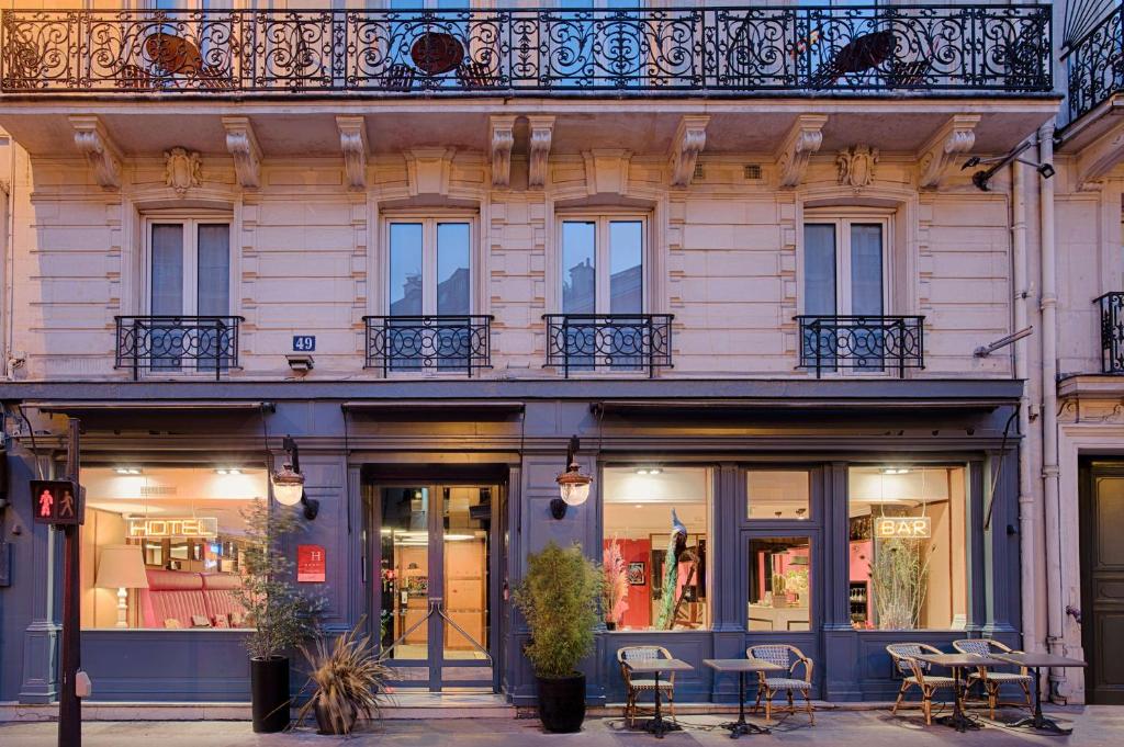 una tienda con mesas y sillas frente a un edificio en NH Paris Opéra Faubourg en París