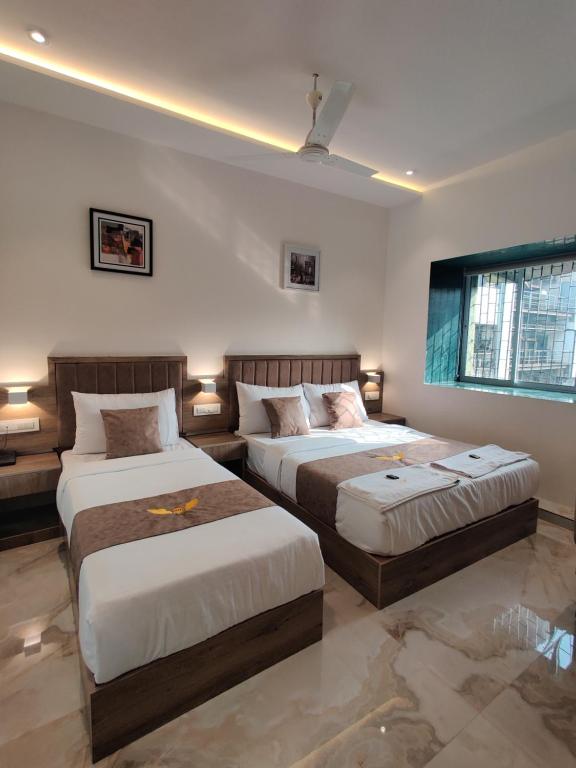 een slaapkamer met 2 bedden en een raam bij MIG SUITES in Mumbai