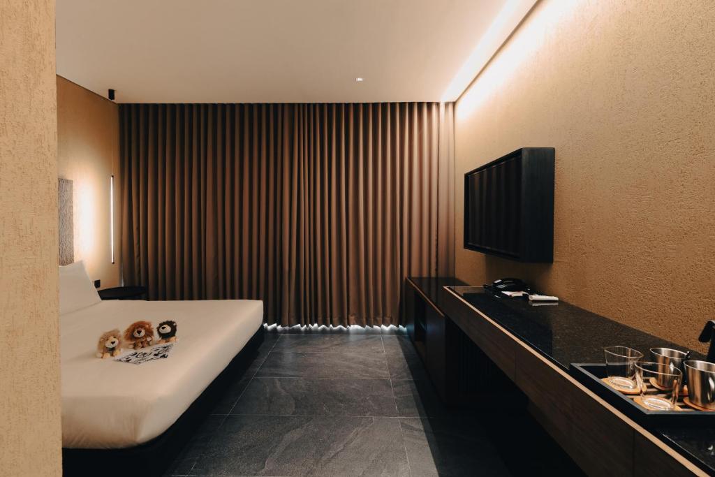 a bathroom with a bath tub and a television in it at The Funny Lion - Puerto Princesa in Puerto Princesa City