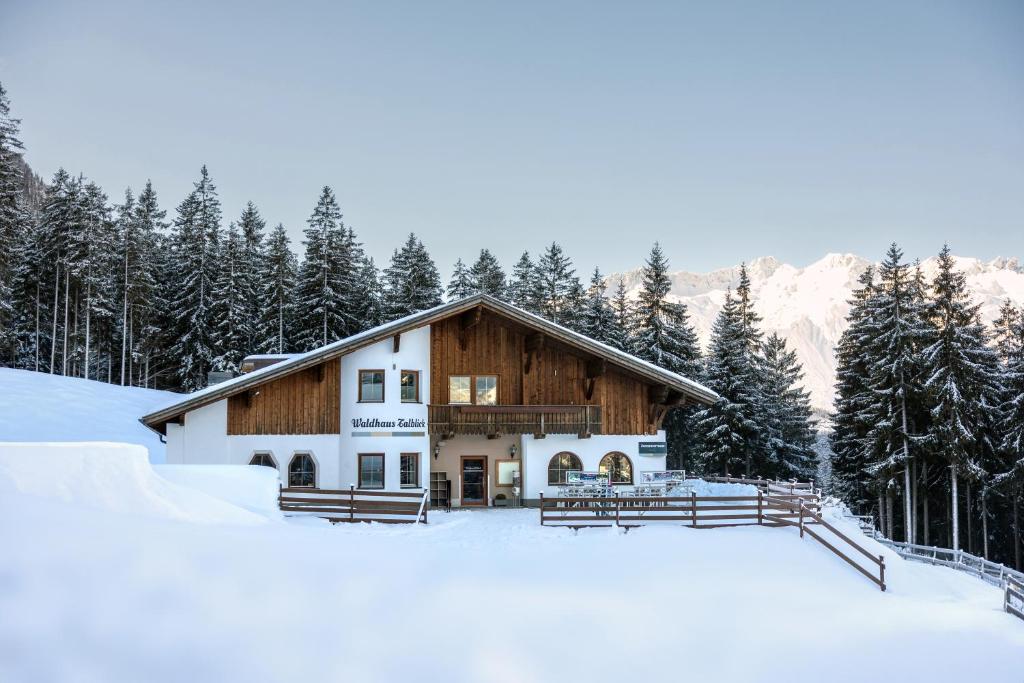 a house in the snow with trees at Waldhaus Talblick in Biberwier