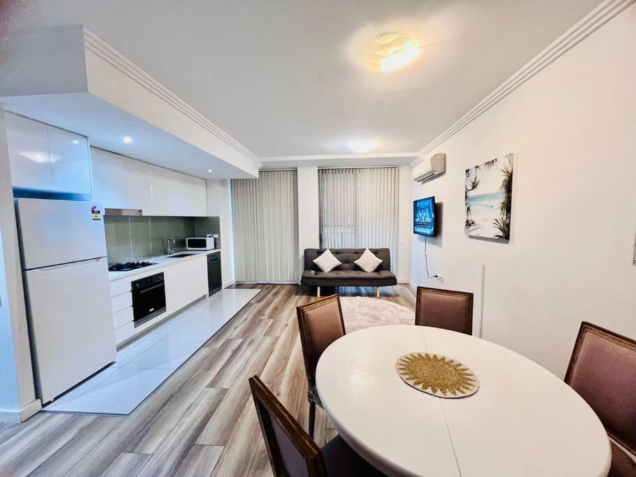 un soggiorno con tavolo e cucina di Apartment in Turrella a Sydney