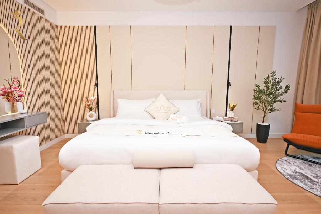 a bedroom with a large white bed and a chair at Sandy 1BR Soul Beach Mamsha Al Saadiyat Island in Abu Dhabi