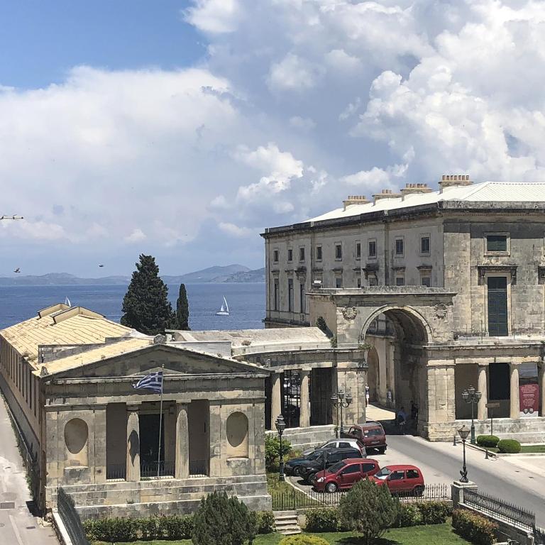 an old building with cars parked in front of it at St. George Liston Suite in Corfu