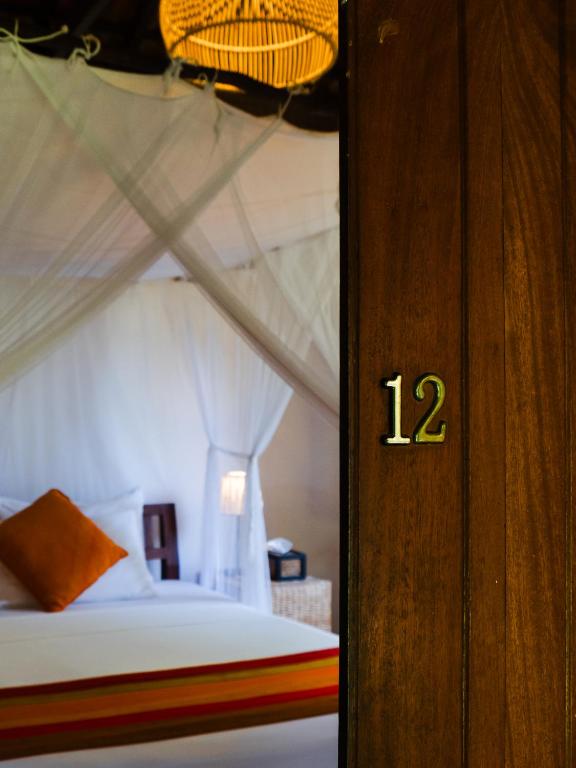Rúm í herbergi á Dunes Unawatuna Hotel