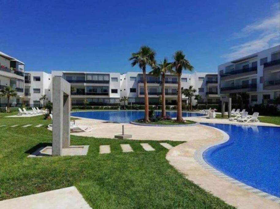 una piscina frente a un gran edificio de apartamentos en Nice appartement Blanca Beach, en Casablanca
