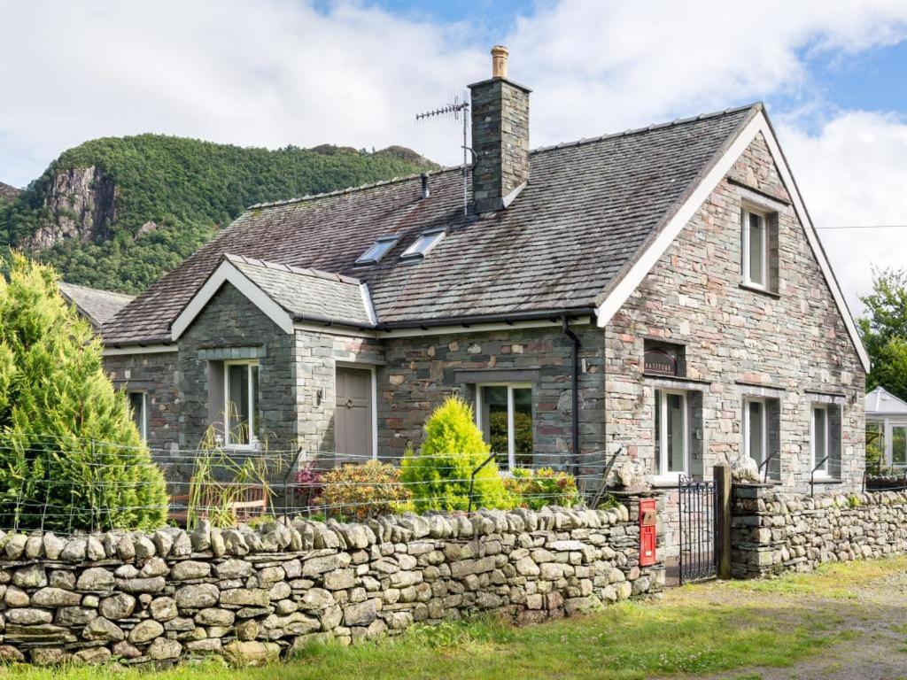 an old stone house with a stone wall at 4 Bed in Borrowdale SZ219 in Grange