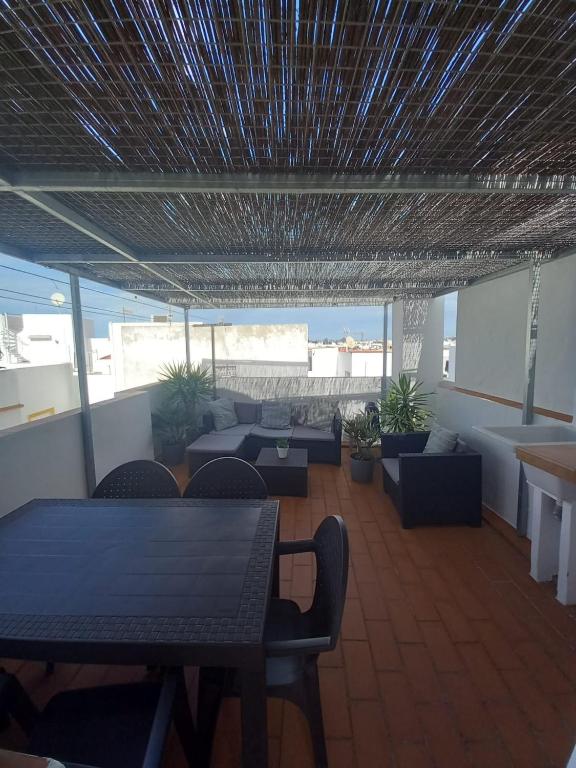 a room with tables and couches and a table and chairs at Casa El Molino in Conil de la Frontera