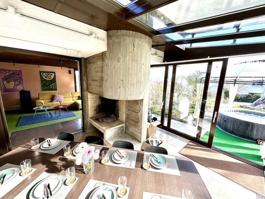 uma sala de jantar com uma mesa e uma lareira em Pool, Jacuzzi, Games, Nature em Adliswil