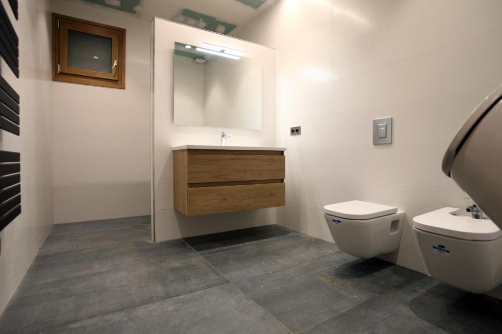 ein Badezimmer mit einem WC, einem Waschbecken und einem Spiegel in der Unterkunft Masvidal in Collsuspina