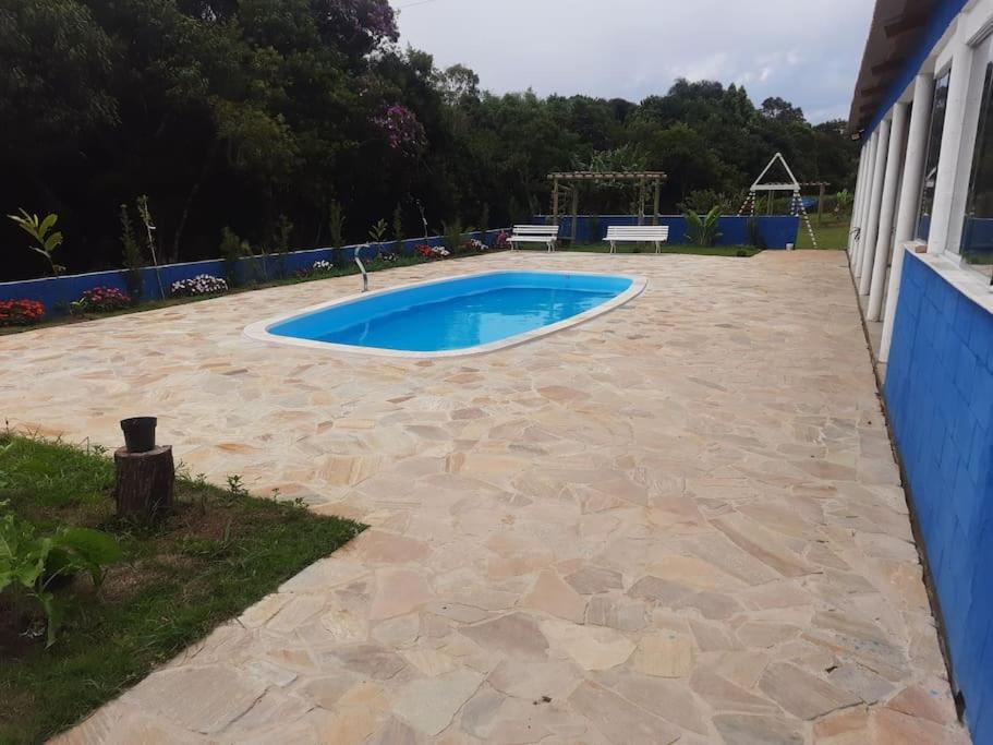 a backyard with a swimming pool and a patio at Chácara Rancho da Felicidade in Mogi das Cruzes