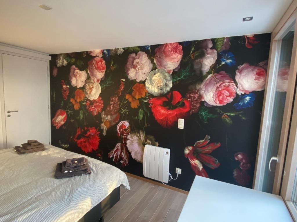ウェームにあるCHAMBRES PERCHEESの花の壁画が壁に施されたベッドルーム