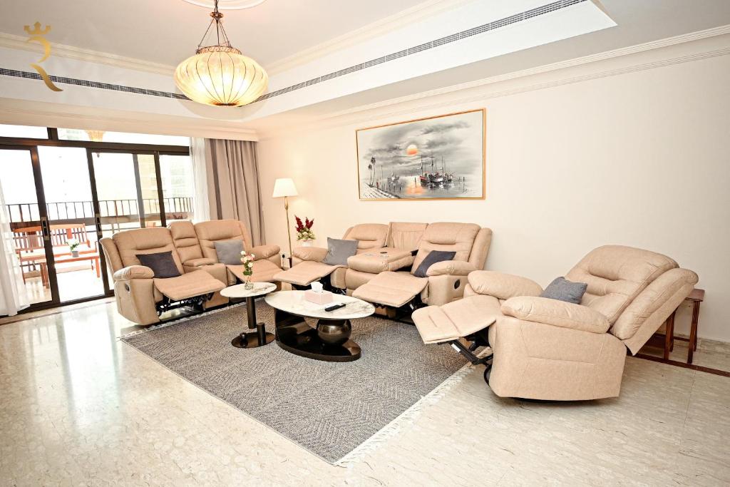 un soggiorno con divani, sedie e tavoli di 3BR Grand Residence Corniche Allure a Abu Dhabi