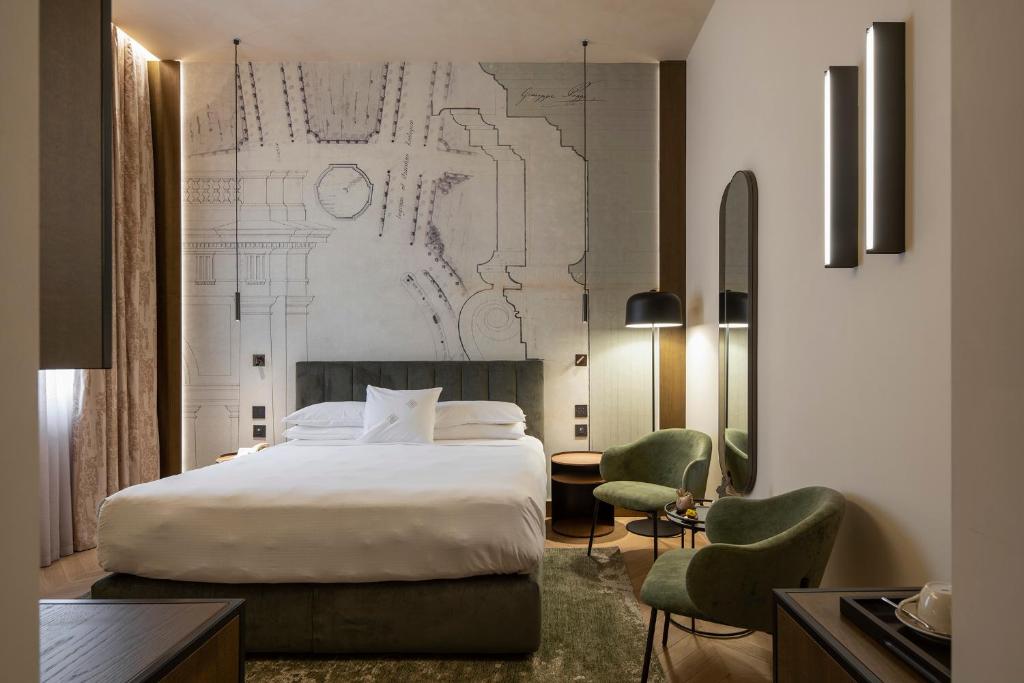 une chambre d'hôtel avec un lit et deux chaises dans l'établissement Palazzo Montebello, à Florence