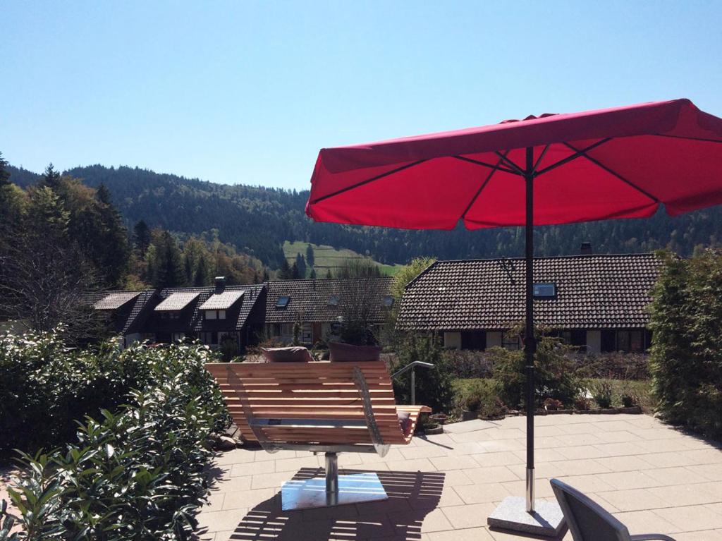 a red umbrella sitting on top of a bench at Ferienhaus Fichte in Todtmoos